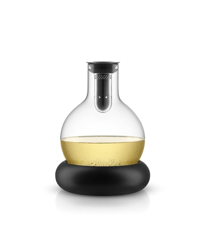 Glass decanter with yellow liquid, black base, and filter on white background